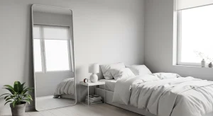  small apartment bedroom with tall mirror reflecting natural light 